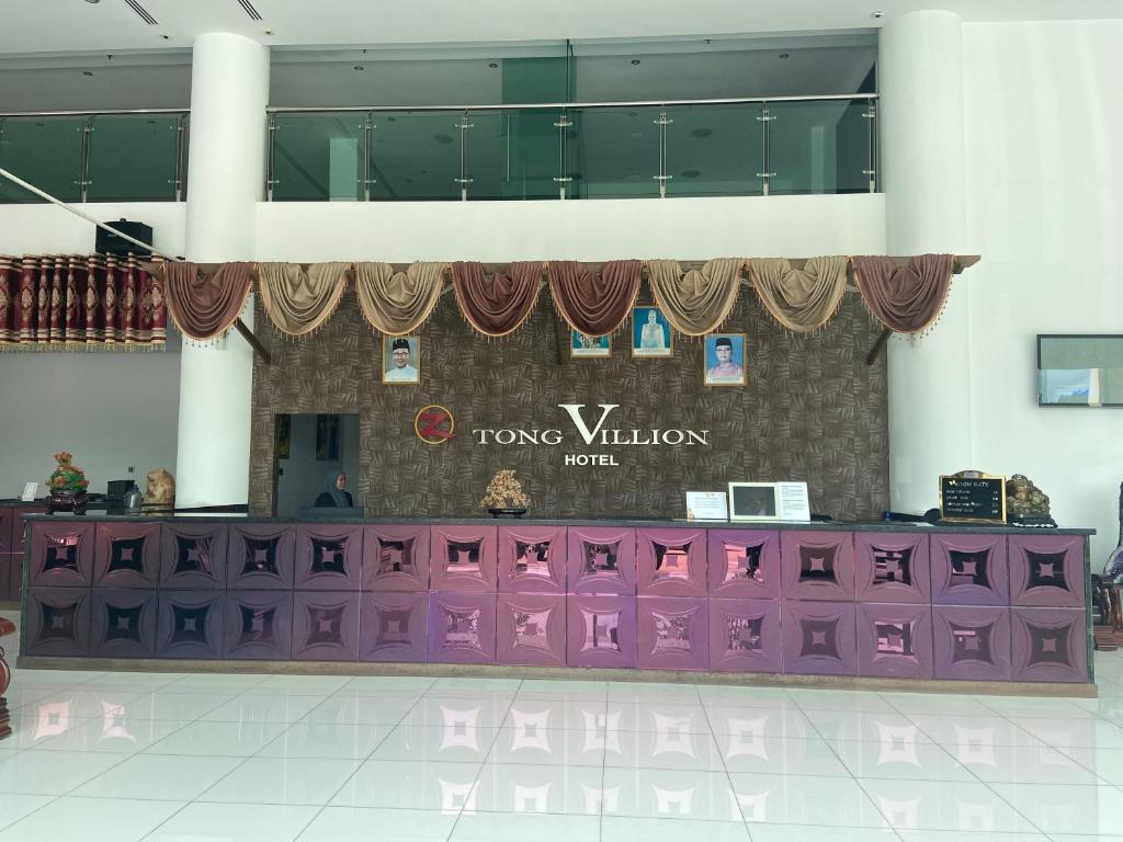 purpurowy stół w pokoju z napisem na ścianie w obiekcie OYO 90934 Tong Villion Hotel w mieście Muadzam Shah