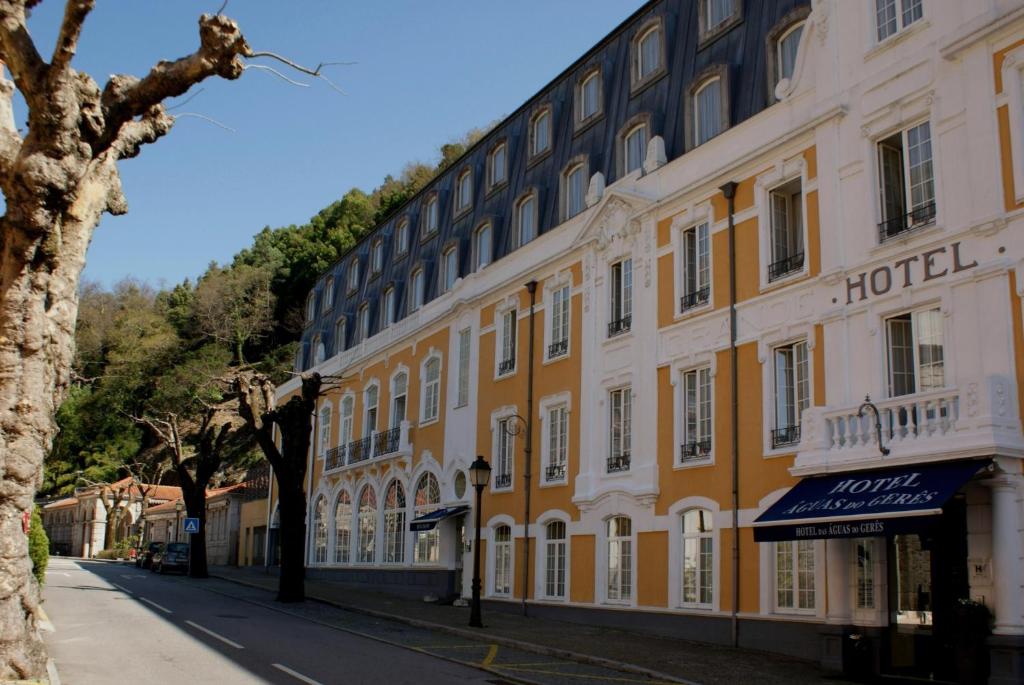 un grande edificio giallo con un hotel su una strada di Águas do Gerês - Hotel, Termas & Spa a Geres