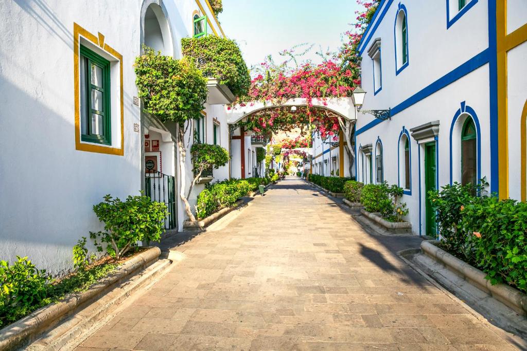 eine Gasse in einer Altstadt mit Blumen in der Unterkunft Billy's Puerto de Mogán Apartments by LIVVO in Puerto de Mogán