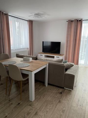 sala de estar con mesa y sofá en Rado Apartments, en Svit