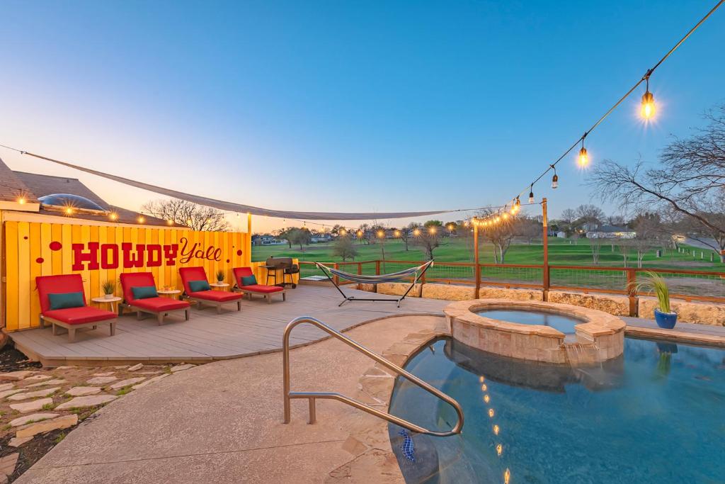 eine Terrasse mit einem Whirlpool und Stühlen neben in der Unterkunft Stunning Pool Overlooking Golf Course & Game Room in San Antonio