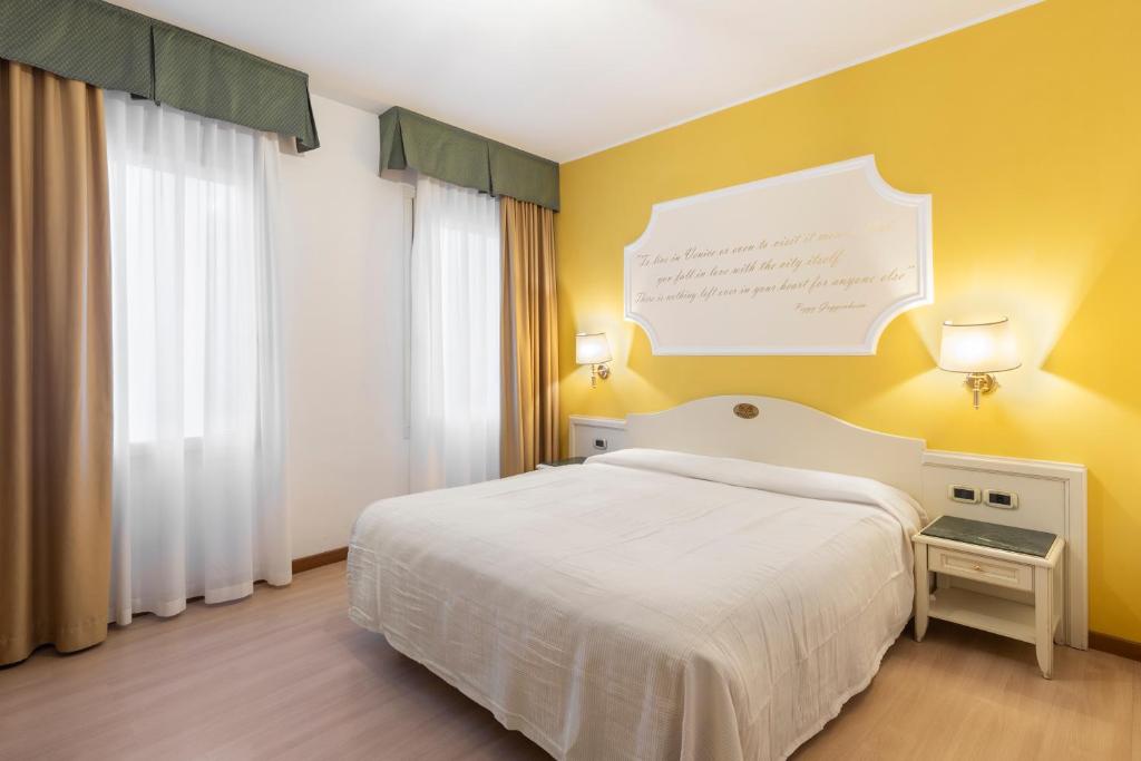 ドーロにあるホテル カトロンのベッドルーム1室(白いベッド1台付)と黄色い壁