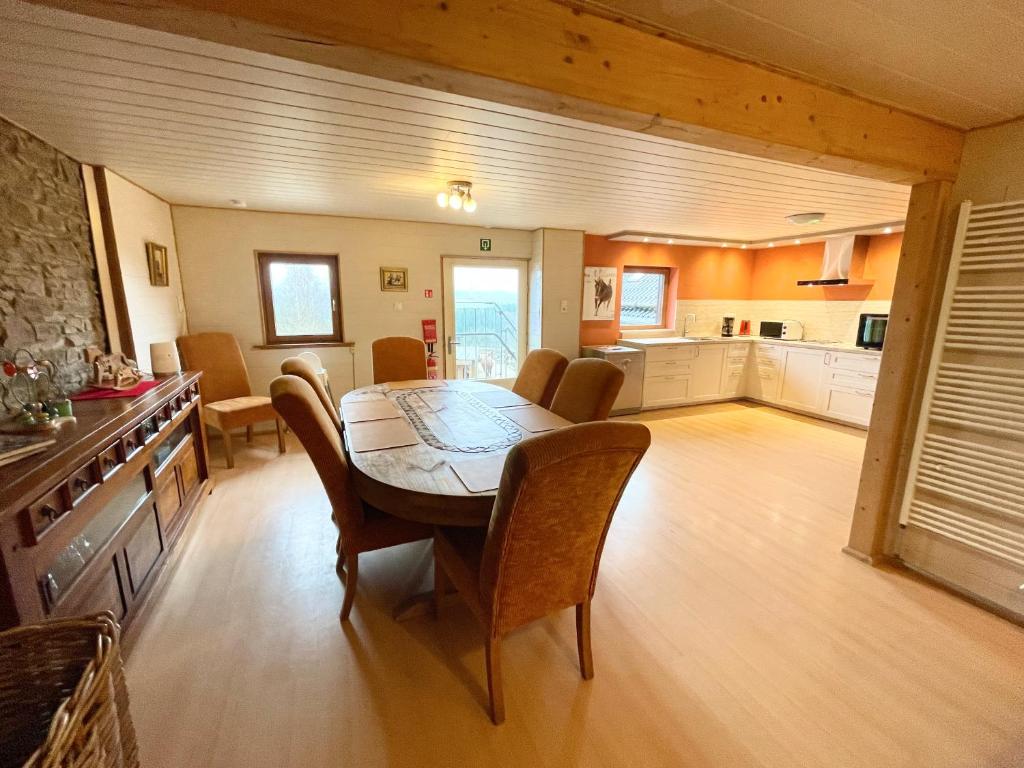 comedor y cocina con mesa y sillas en Revival Ranch Ferienwohnung, en Büllingen