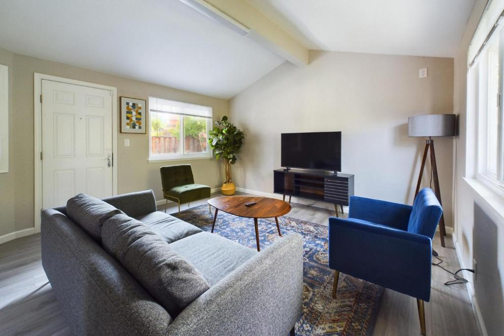 ein Wohnzimmer mit einem Sofa, Stühlen und einem TV in der Unterkunft South San Jose 3br w garage wd backyard SFO-1506 in Campbell