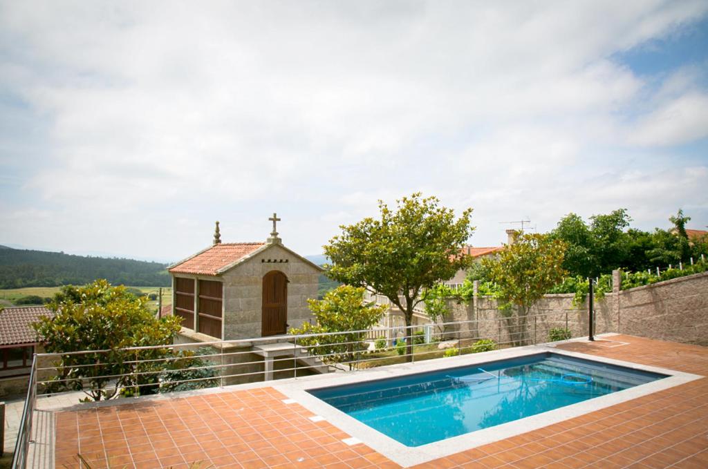 a house with a swimming pool and a church at 4 bedrooms house with private pool jacuzzi and enclosed garden at Magan in Cuntis