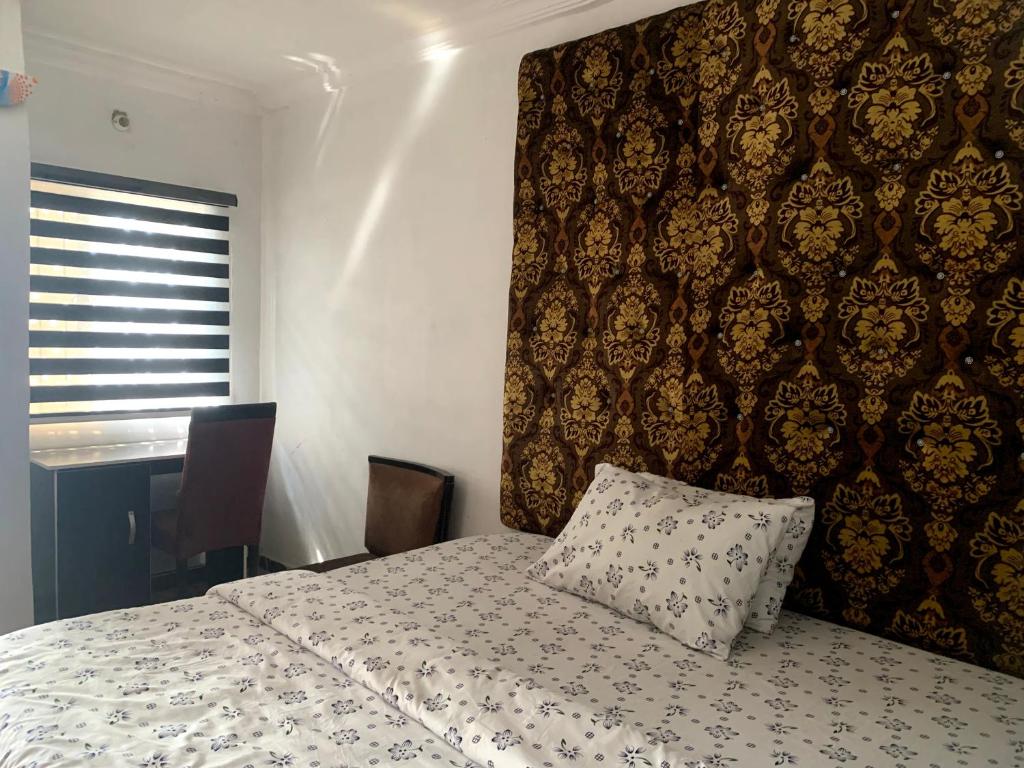 a bedroom with a bed with a pillow on it at New Travellers Lodge Sangotedo Lagos in Lekki