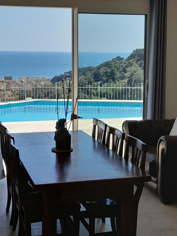 a dining room table with a view of a pool at Family Home - Between Monaco, Menton & Gorbio - Beautiful in Gorbio