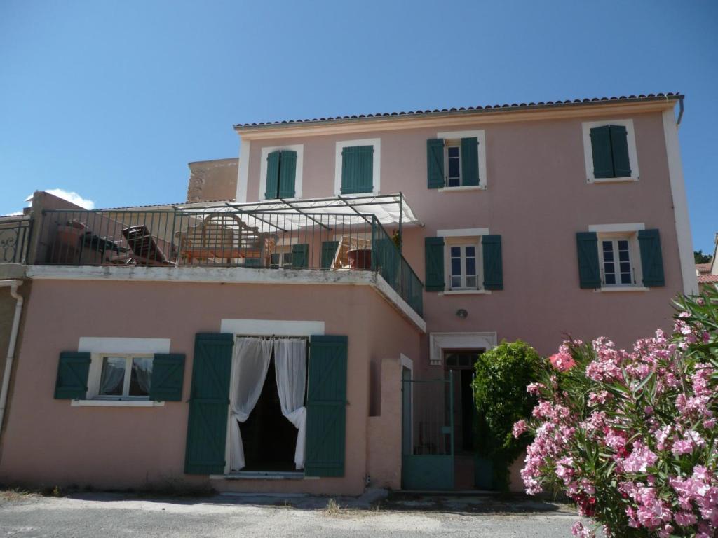 une maison rose avec des vêtements suspendus par la fenêtre dans l'établissement Les Tilleuls, à Olmi-Cappella