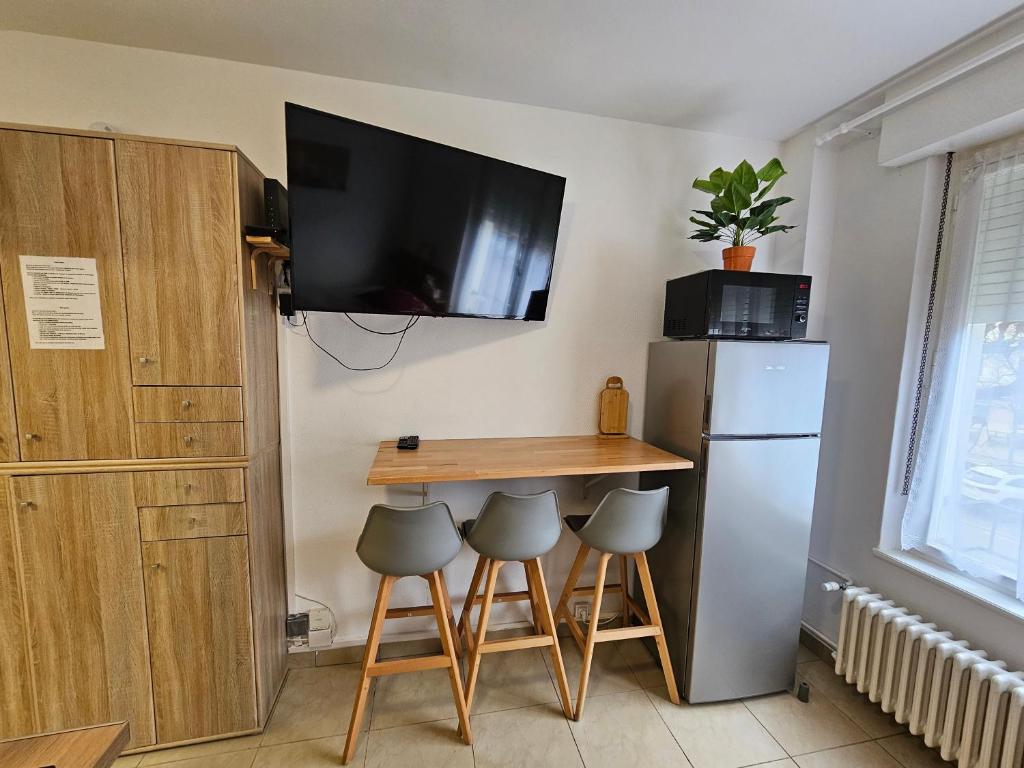 a small kitchen with a table and a refrigerator at Studios Immostrasbourg - hébergements de tourisme classés proche centre et Conseil d'Europe in Strasbourg