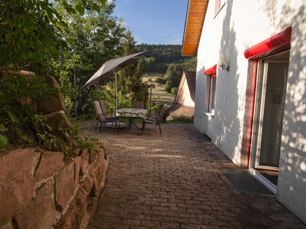 a table and chairs with an umbrella on a patio at Haus Karle in Ettenheim