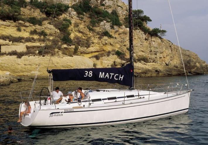 dos personas sentadas en un velero en el agua en Durma a bordo de um veleiro agradável em Lisboa, en Lisboa