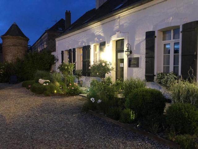 una casa blanca con un jardín delante de ella en La clé des Champs en Saint-Josse