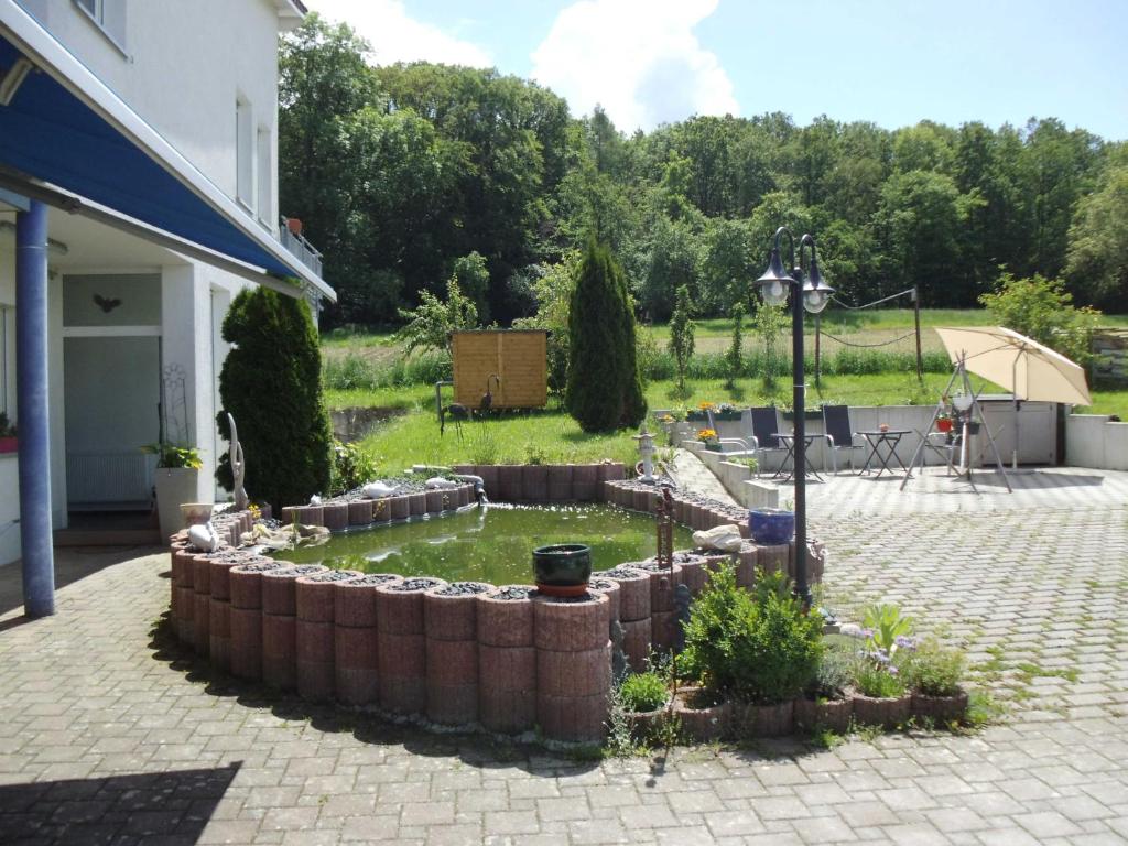 um quintal com uma parede de retenção e um jardim em Martini Pension Rammert em Großbettlingen