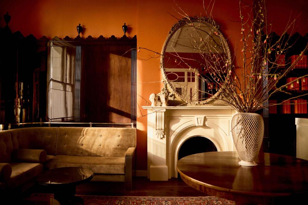 salon z kanapą, stołem i lustrem w obiekcie Grand Hotel Bellevue London w Londynie