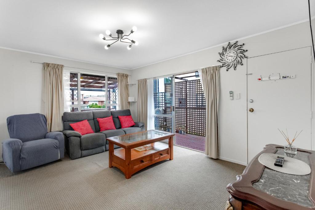 sala de estar con sofá y mesa en Homespun Unit with deck, air-con and parking en Auckland
