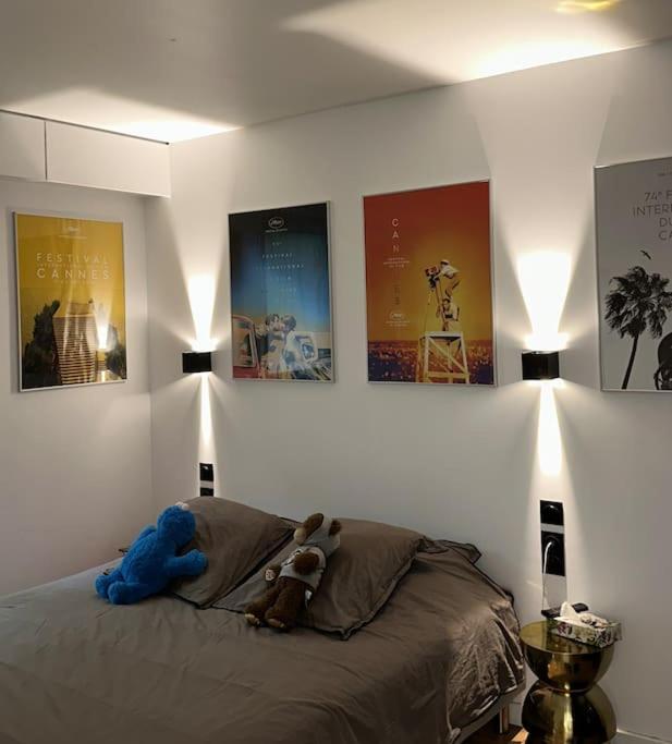 une chambre avec un lit avec deux animaux en peluche dessus dans l'établissement 2 pièces calme sur jardin, Centre Ville, à Boulogne-Billancourt