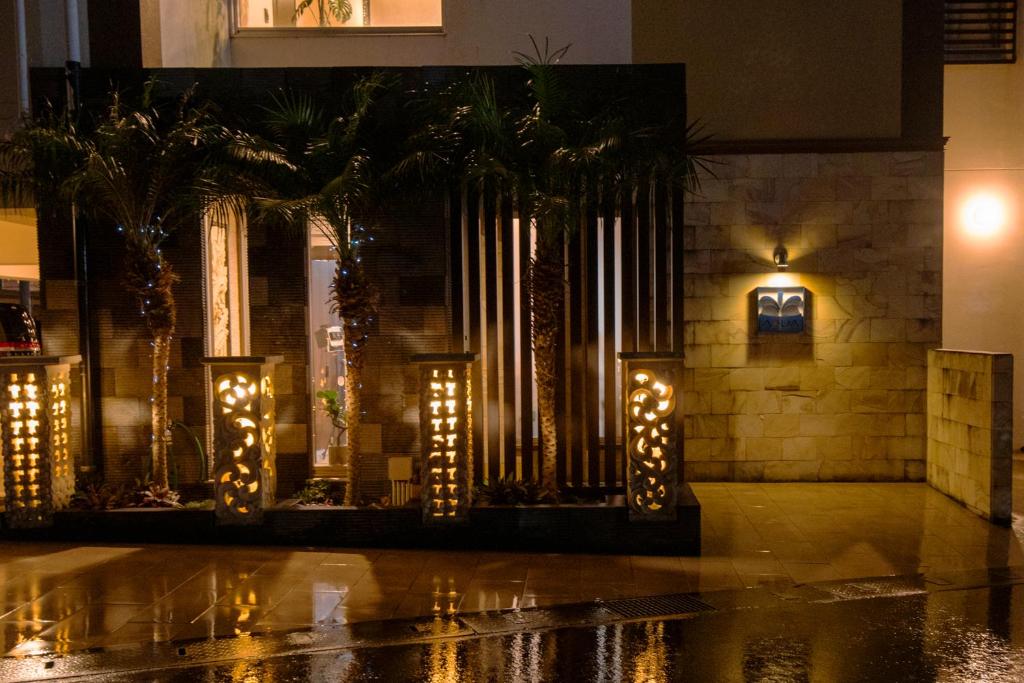 un grupo de palmeras con luces en un edificio en Aqua Resort in Chatan, en Chatan