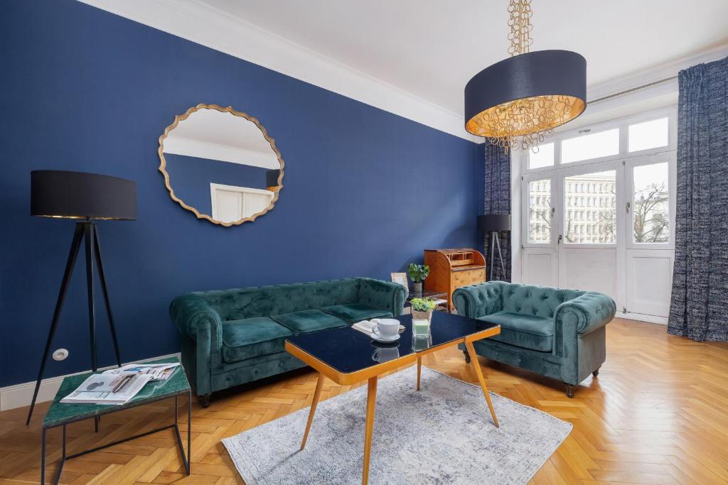 ein Wohnzimmer mit 2 grünen Sofas und einem Spiegel in der Unterkunft Luxury Apartment with Two Bedrooms and Balcony by Renters Prestige in Krakau