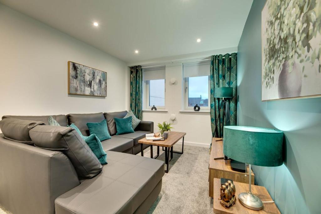 uma sala de estar com um sofá e uma mesa em All Saints Apartments 606 by Week2Week em Newcastle upon Tyne