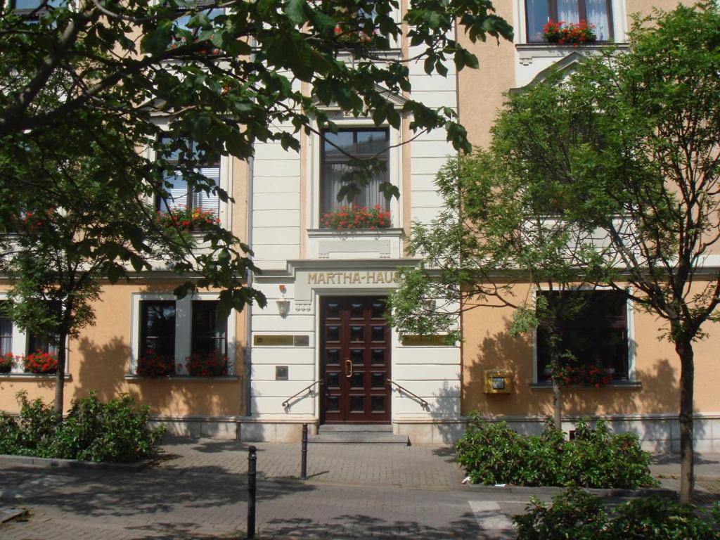 un edificio con una puerta y flores en las ventanas en Hotel Marthahaus, en Halle an der Saale