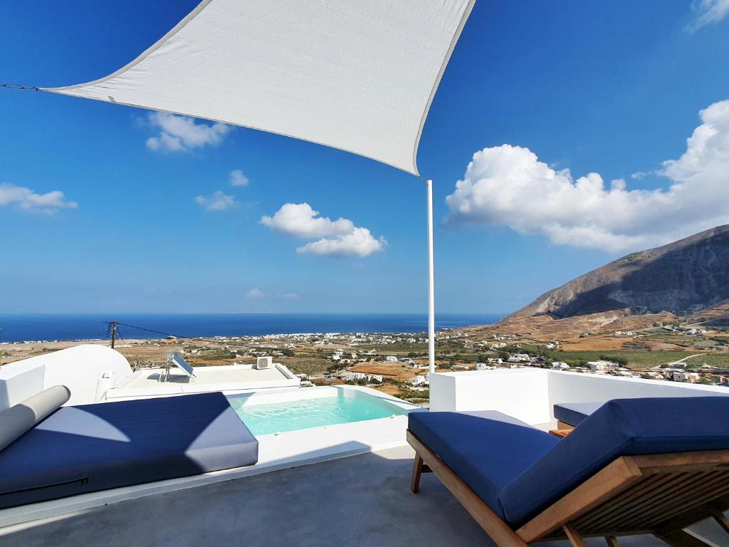 a villa with a swimming pool and an umbrella at Sun Spell Villa - with private hot tub up to 6 pax in Fira