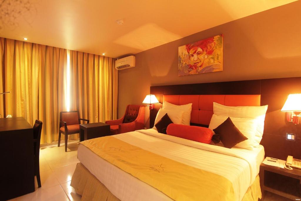 una habitación de hotel con una cama grande en una habitación en Oakspring Hotel and Luxury Suites, en Lagos