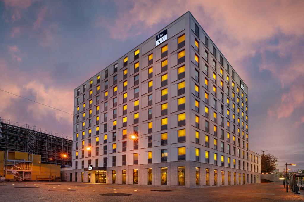 a tall gray building with yellow windows at dusk at the niu Ridge in Halle an der Saale
