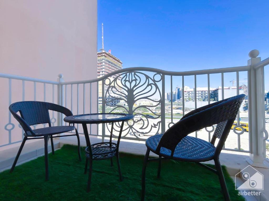 two chairs and a table on a balcony with a view at Gorgeous 1 bedroom with balcony in JVC in Dubai