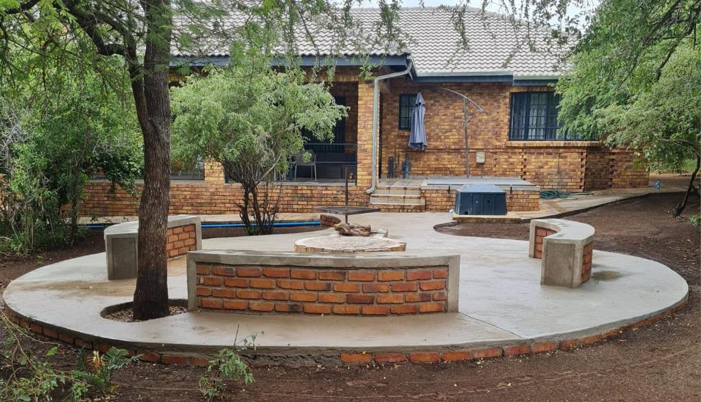 a brick building with a bench and a table at Shades of Nature in Marloth Park