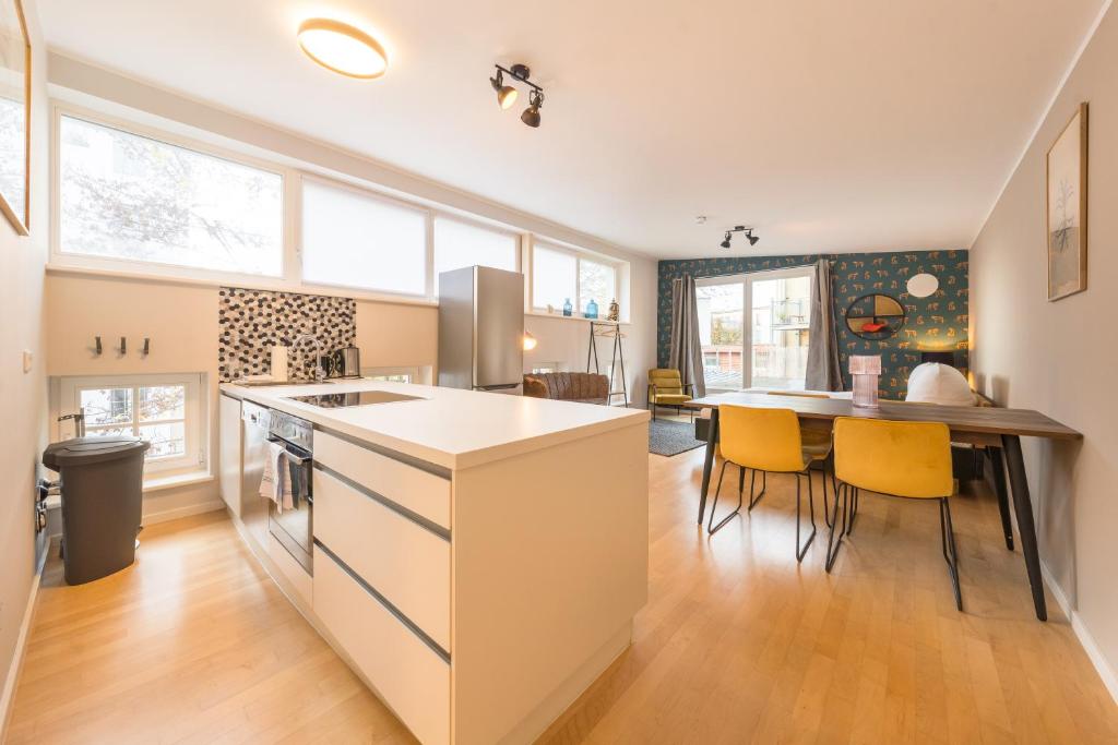 eine Küche und ein Esszimmer mit einem Tisch und gelben Stühlen in der Unterkunft Design Apartments Potsdam West in Potsdam