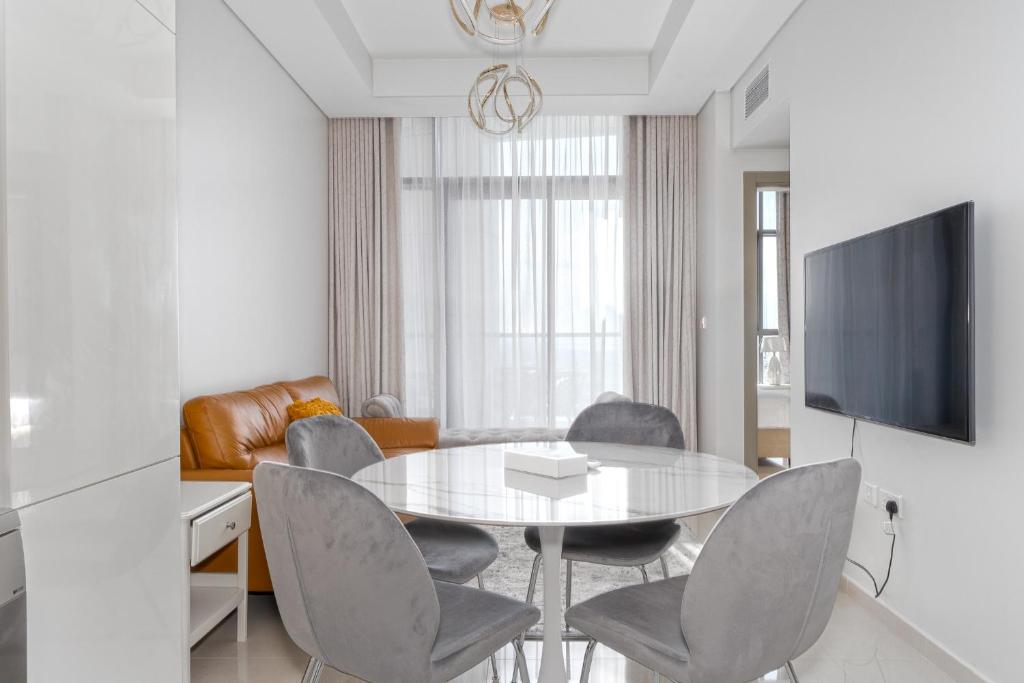 a dining room with a table and chairs and a tv at ALH Vacay - Aykon City 2 Tower C - 2 bedrooms in Dubai