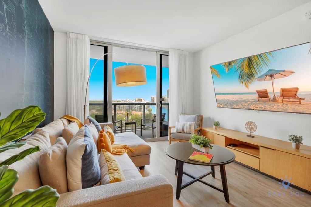 Una sala de estar con sofá y vista a la playa. en Infinite Views, Amazing Pool, Gym, Near Beach, en Hallandale Beach