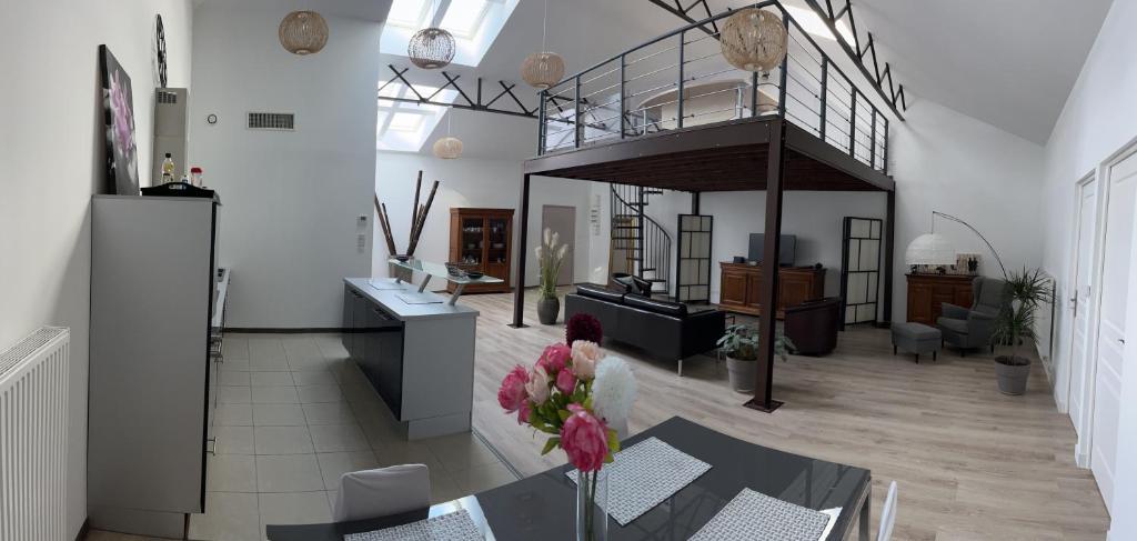 Il comprend un salon avec une table et une cuisine. dans l'établissement LE FAUBOURG SAINT MARTIN, à Senlis