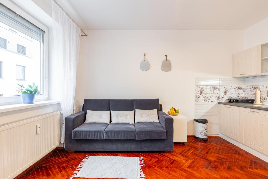 un salon avec un canapé dans une cuisine dans l'établissement CitySerenity Rustic Apartment, à Bratislava