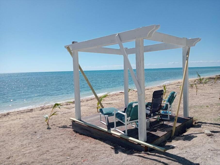 a gazebo on the beach with two chairs at Oceanview at Coral Habour in Nassau