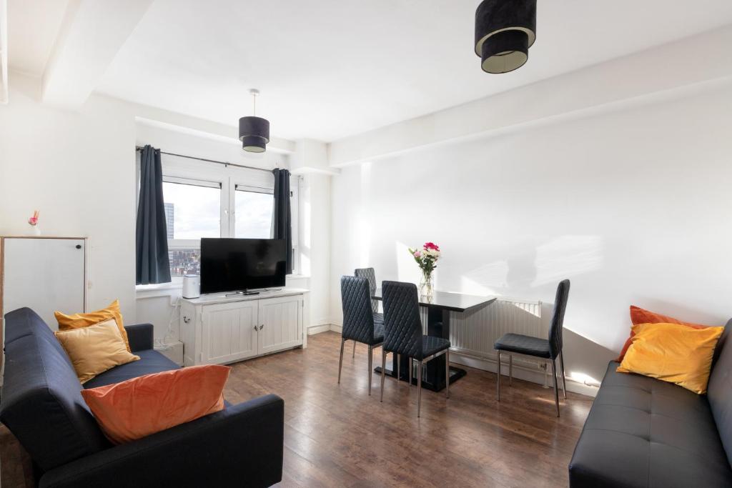 a living room with a couch and a table at 2 bed Bethnal Green Penthouse in London