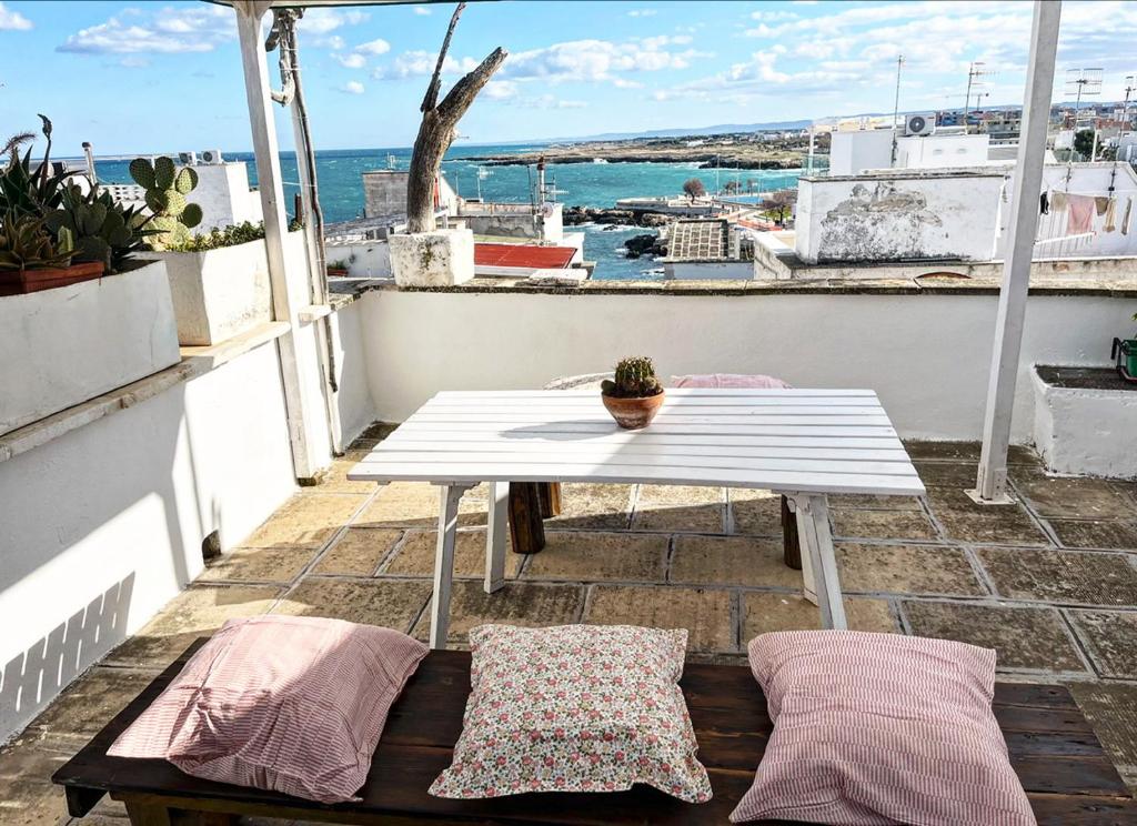 a white table on a balcony with a view of the ocean at Arco Sallustio 2.0 in Monopoli