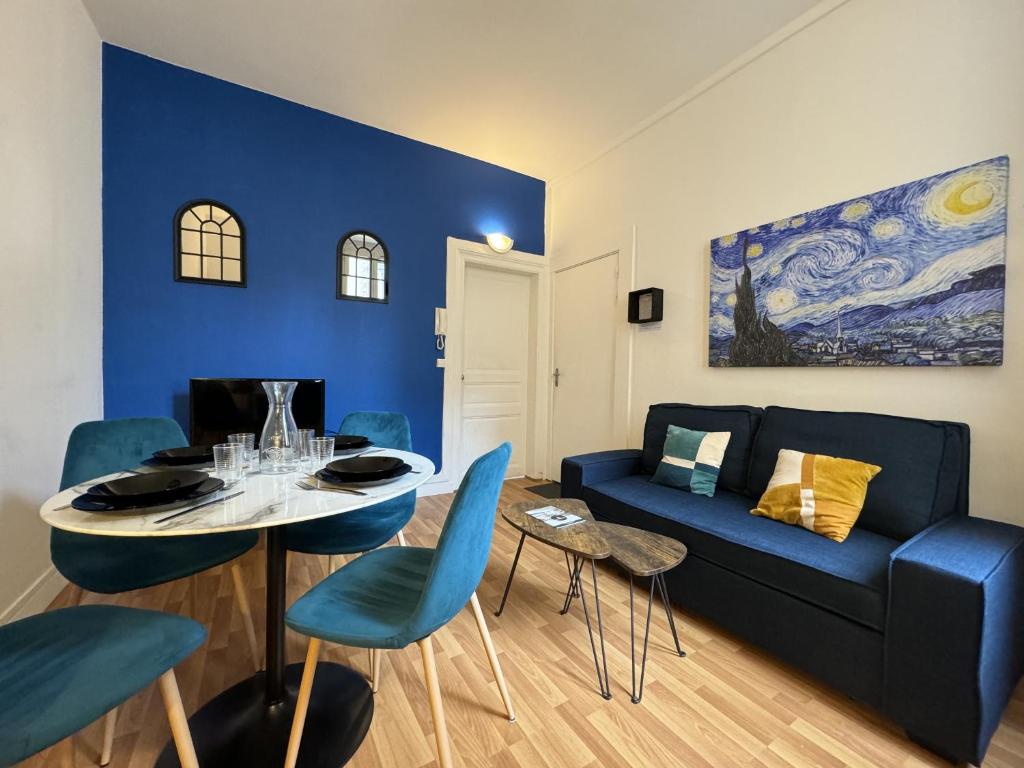 un salon avec un canapé bleu et une table dans l'établissement Van Gogh Home - Centre - 4p - Rêve au Mans, au Mans