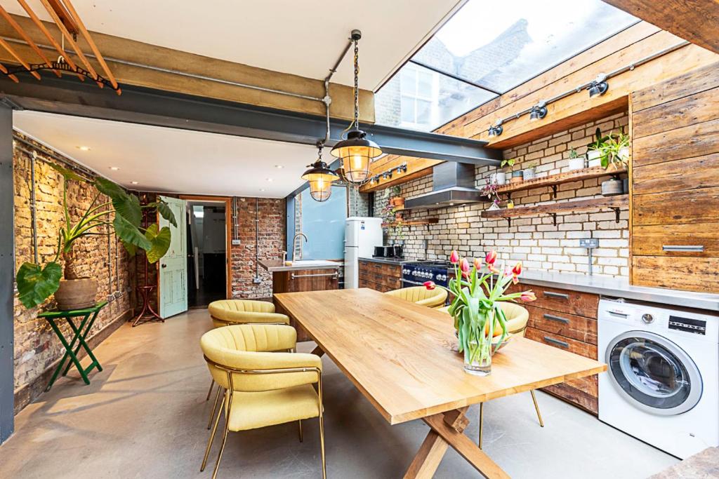 a kitchen with a wooden table and a washing machine at Hackney - Victoria Park Generous 2 Bed Terrace in London