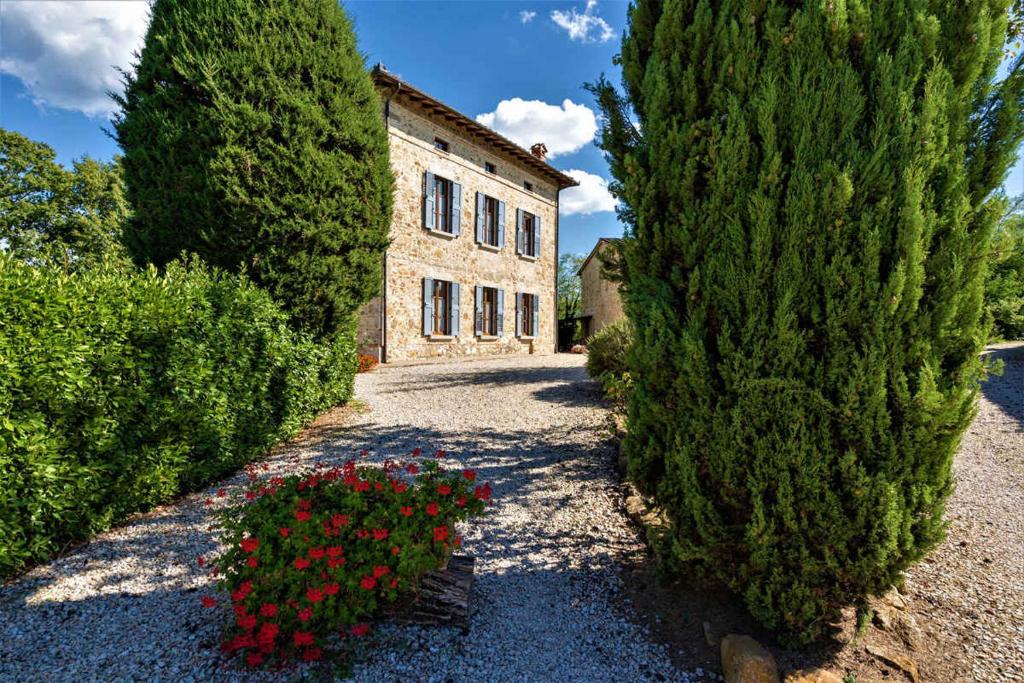 a house with trees and flowers in front of it at Apartment in Casole d'Elsa - Toskana 24073 in Casole dʼElsa