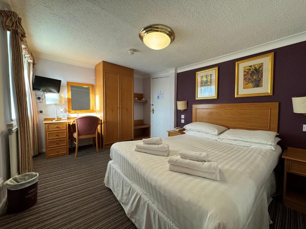 a hotel room with a large bed with towels on it at The Chatsworth Hotel in Worthing