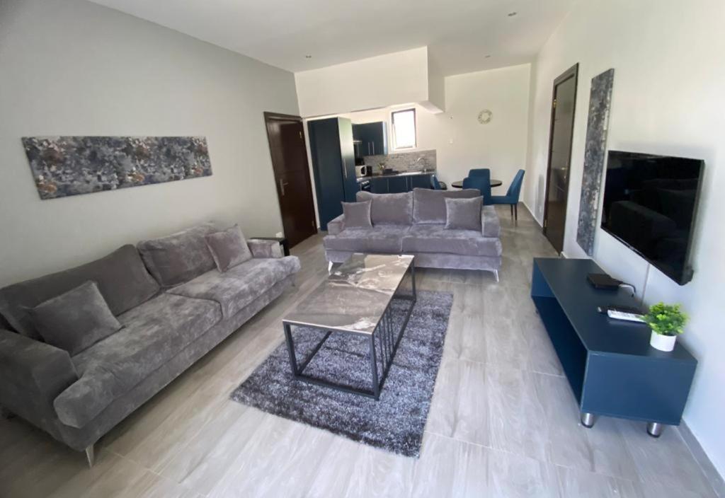 ein Wohnzimmer mit einem Sofa und einem Tisch in der Unterkunft Ibex Blue 2 Bedroom in Lusaka