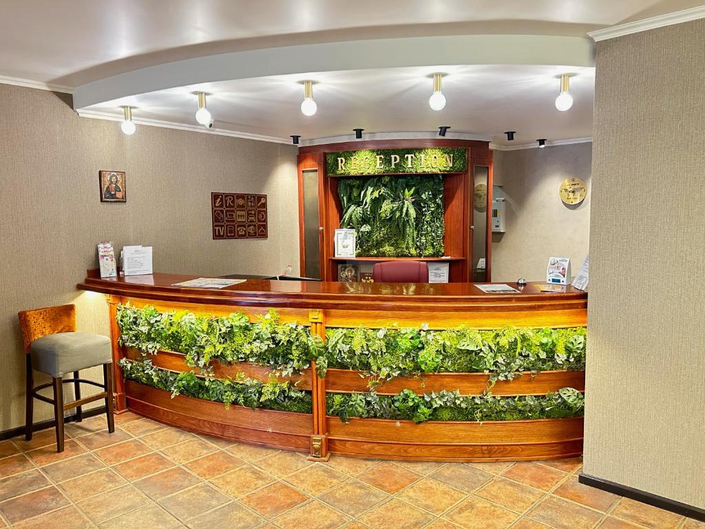 a bar in a restaurant with a green wall at Hotel Orbita in Varna City
