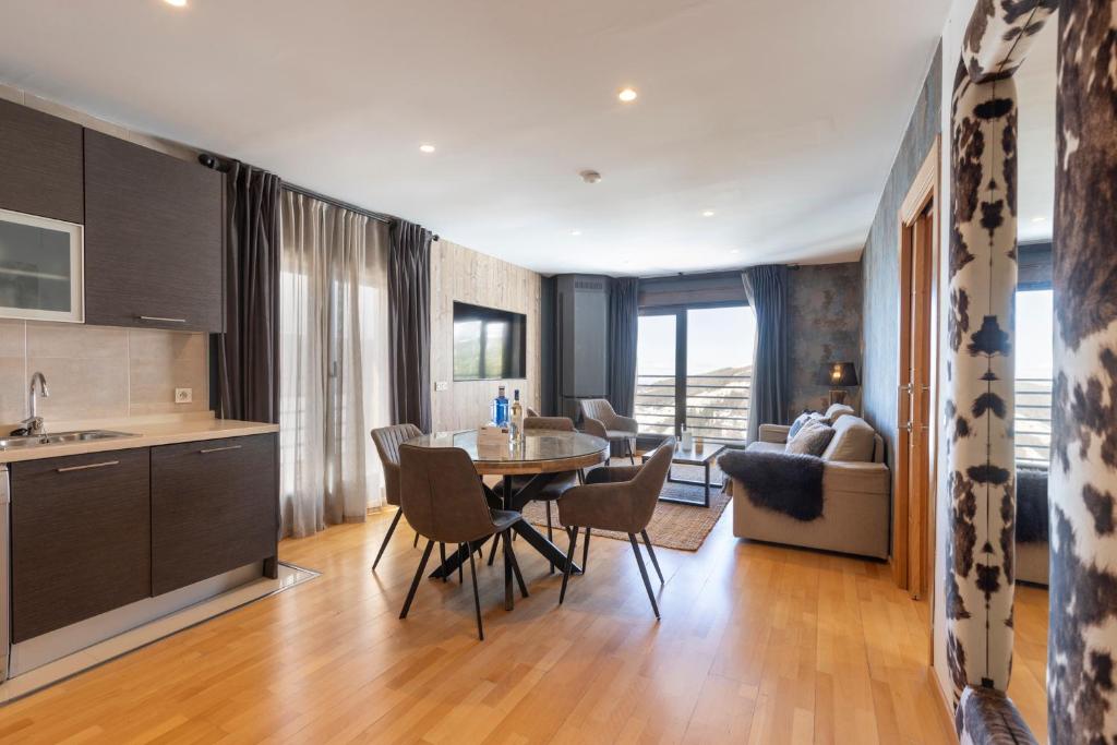 una cucina e un soggiorno con tavolo e sedie di BiBo Suites Sierra Nevada a Sierra Nevada