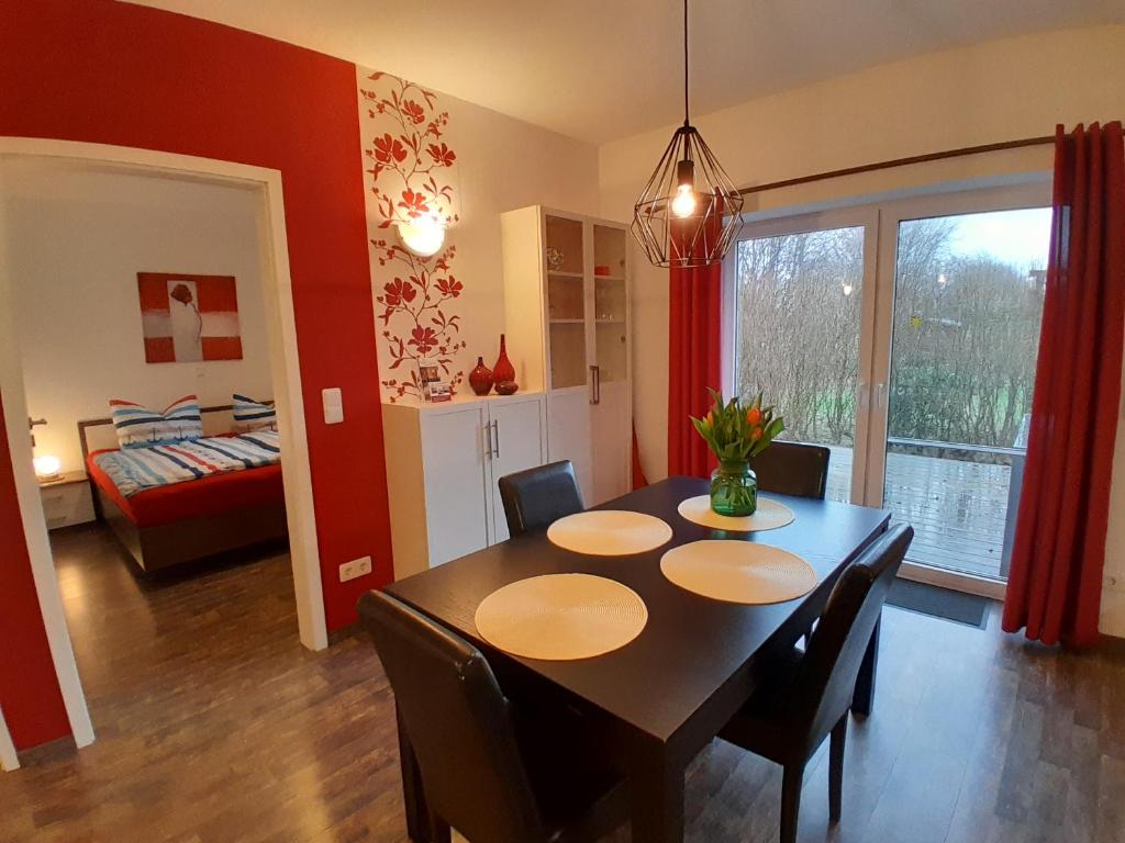 un comedor con mesa y sillas y un dormitorio en Wikingerland Typ 1 Erdgeschoss, en Langballig