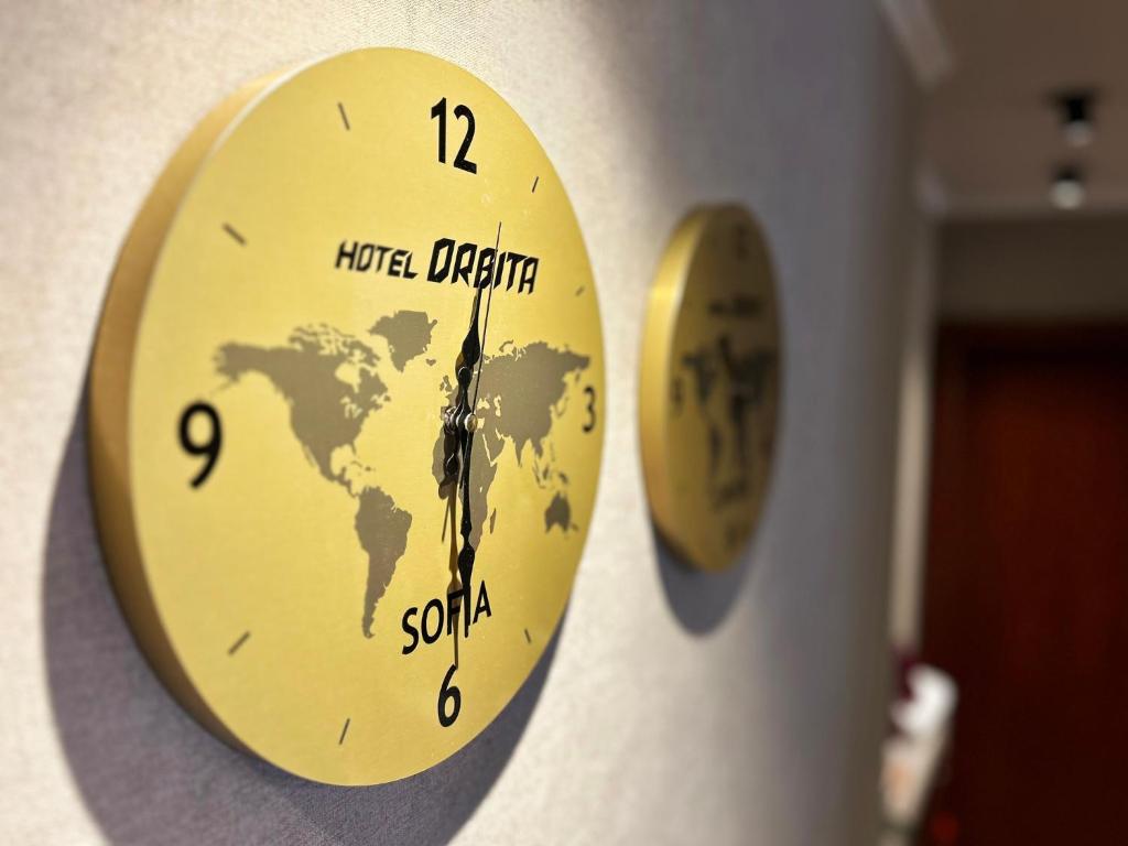 a clock hanging on a wall with the names of the world at Hotel Orbita in Varna City