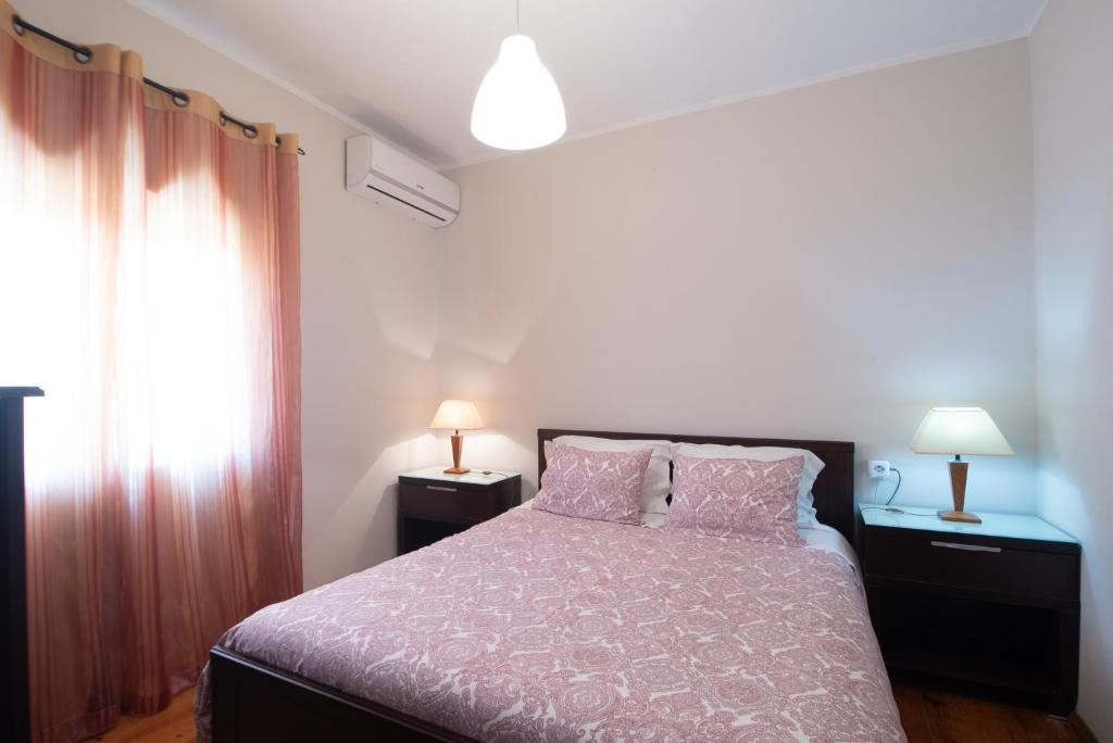 sypialnia z łóżkiem, 2 lampami i oknem w obiekcie PortoMar House Apartament w mieście Leça da Palmeira