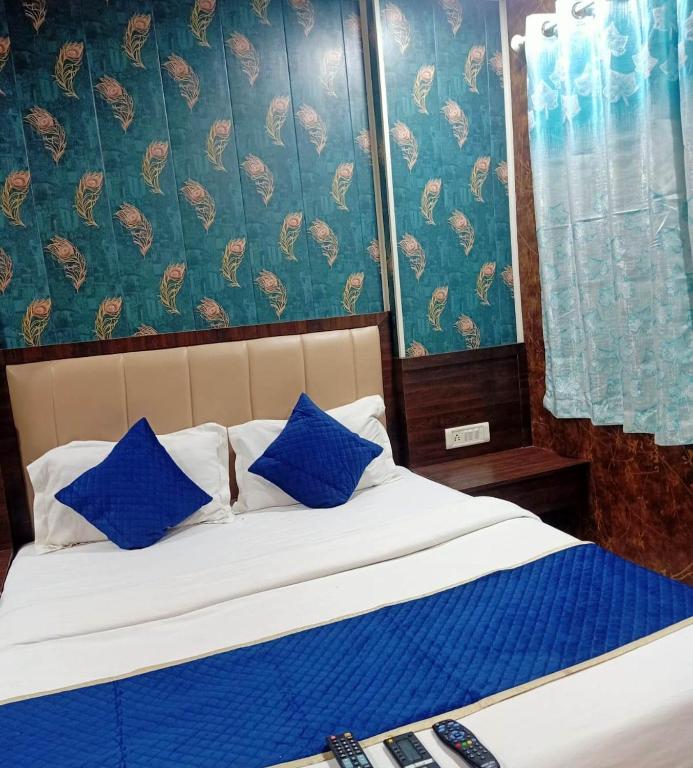a bed with blue and white pillows in a room at HOTEL MANTRA NX in Mumbai