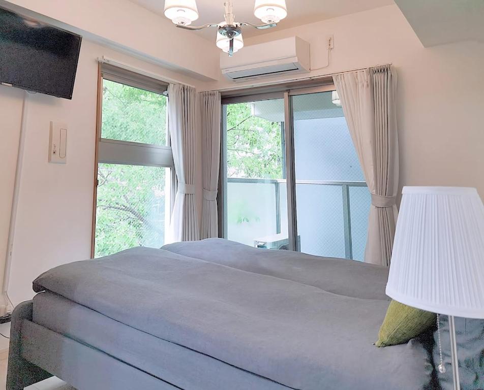 um quarto com uma cama e uma grande janela em OSAKA SUNSHlNE TOWER23 em Osaka