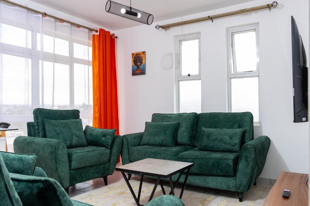 a living room with two green chairs and a table at Anga Nest a chic One-Bedroom Ngong Road in Nairobi